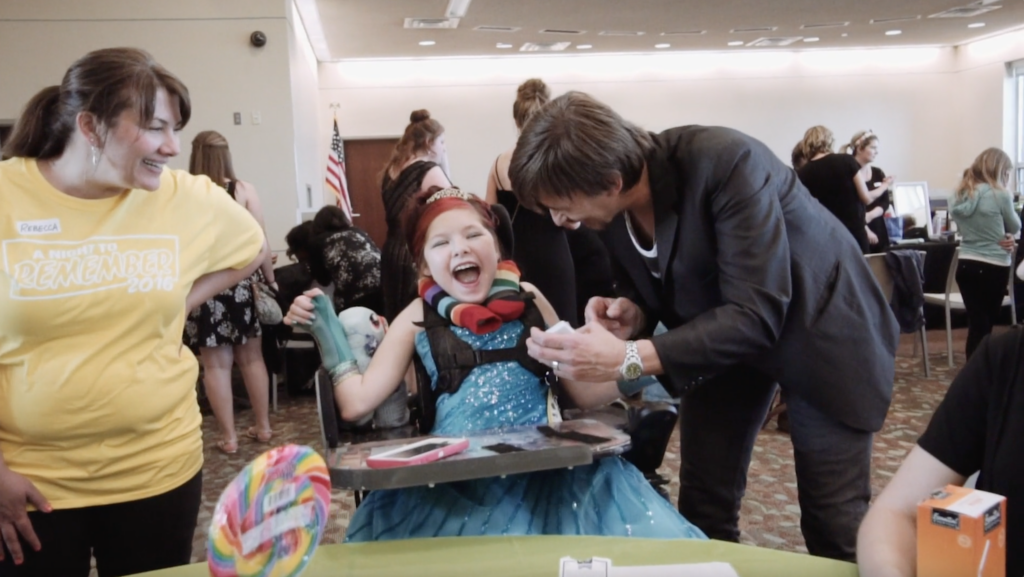 Tim Gabrielson does magic for a girl in a wheelchair